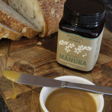 Mason Brothers Manuka Honey MGO 100+ next to bread